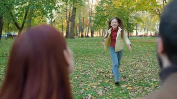 快乐可爱可爱可爱可爱的小女孩女儿快跑跑奔向父母妈妈爸爸在户外公园接妈妈爸爸亲热的家人假期快乐的玩耍 — 图库视频影像
