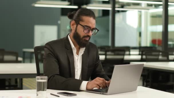職場テーブルエスニックビジネスでアラビア人の男のインドのオフィスワーカー 起業家男性 コンピュータで働くノートパソコンのブラウジングをタイプする男 ペンギンはオンライン仕事の思考を終えます — ストック動画