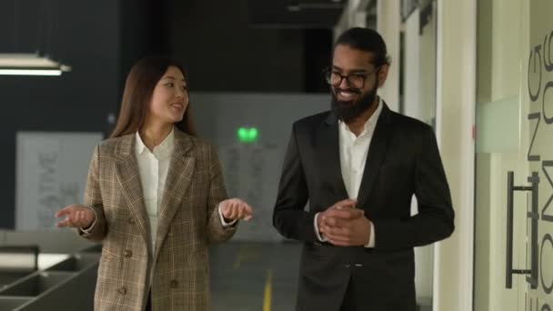 多様な多種多様な同僚は オフィス廊下のロビーを歩いているビジネスの人々は 新しいスタートアッププロジェクトを議論フレンドリー笑顔で インドのアラビアのビジネスマンとアジアの韓国のビジネスマンと話します — ストック動画