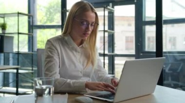 İş kadını laptopta çalışan Kafkas iş kadını genç girişimci yönetici bilgisayar işlerinde çalışan kafası karışmış gözlüklü kötü görüşlü gözlüklü ofis kamerasındaki görme sorununa bakıyor.