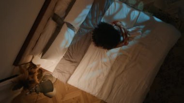 Depresif depresyon geçiren üzgün bir genç kadın karanlık bir gece odasında yalnız başına üzgün bir kız dizlerine sarılıyor evde yatağında akıl sağlığı depresyonunda yatıyor.