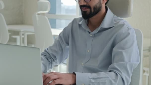 印度穆斯林商人阿拉伯商人企业家办公室经理雇主首席执行官执行程序员业务在现代办公场所使用笔记本电脑看着相机笑 — 图库视频影像
