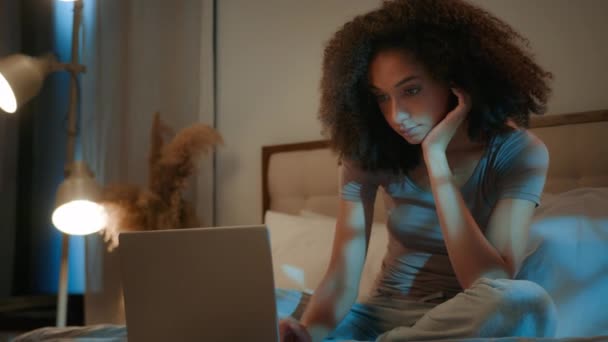 ナイトダークベッドルーム アフリカ系アメリカ人女性ラップトップデバイスでコンピュータ画面検索 女性のビジネスマン 働く締め切り少女 オンラインで映画を選択する 眠れない夜の不眠症 自宅で — ストック動画