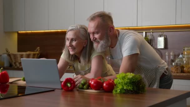 Orta Yaşlı Beyaz Çift Mutfağında Dizüstü Bilgisayar Kullanarak Ailelerini Kullanıyor — Stok video
