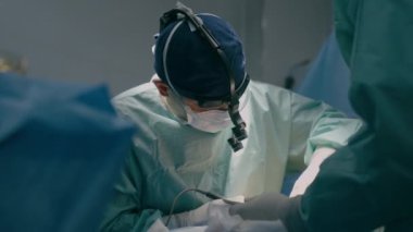 Ekip cerrahları, modern tıbbi endoskopik aletlerle ameliyat odasındaki uzman doktor pratisyen hekimlerinde ameliyat yapıyorlar. Kalp ameliyatı, hastanedeki kanser tümörü cerrahi sağlık prosedürünü kaldırıyor.