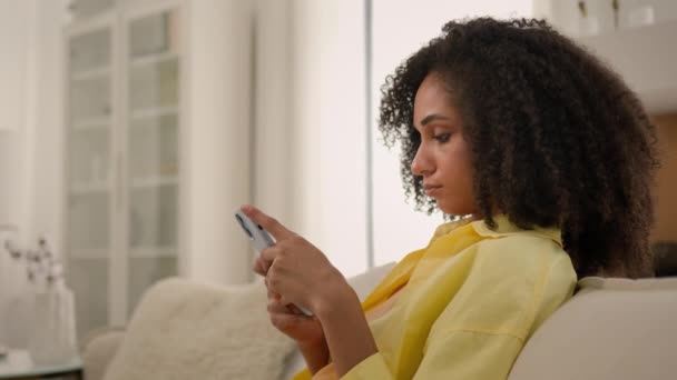 悲しい退屈な退屈なアフリカ系アメリカ人女性は ホームスクロールニュース携帯電話中毒ソーシャルメディア うつ病疲労の疲労の退屈をソーシャルメディア — ストック動画