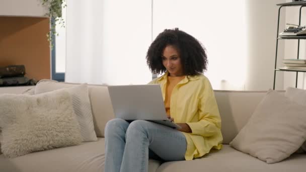 아프리카계 미국인 프리랜서 소파에 노트북과 일하는 쇼핑객 사업가 아파트에서 온라인 — 비디오