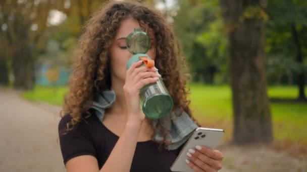 Joven Mujer Caucásica Deportista Beber Agua Botella Deportes Utilizar Teléfono — Vídeo de stock