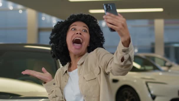 Radosna Dziewczyna Afroamerykanka Blogger Biorąc Selfie Zdjęcie Salonie Samochodowym Zakup — Wideo stockowe