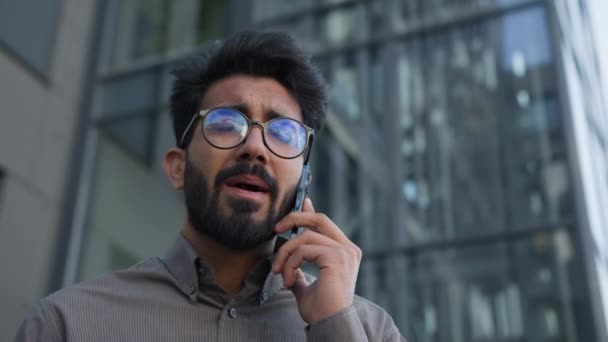 印度男子阿拉伯裔穆斯林商人在户外讲手机男性企业家领袖雇主首席执行官办公室经理职业经纪人接听市中心的智能手机电话 — 图库视频影像
