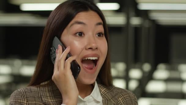 同僚やパートナーとの携帯電話の会話を保持しているアジアの少女韓国のビジネスマン 日本のビジネス女性中国の女性は オフィスで成功を達成する素晴らしい良いニュースコールを聞く — ストック動画
