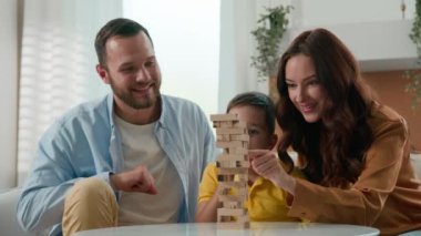 Mutlu, şakacı, beyaz bir aile babası, anne, baba, baba, oğul, çocuk, entellektüel, mantıklı bir masa oyunu oynayın. Oturma odasında, kulede bulmaca oynayın.