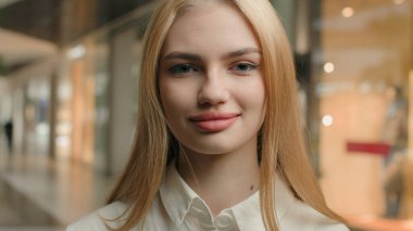 İş kadını, Kafkasyalı, 20 'li yaşlarda kadın, giyim mağazası, giyim mağazası, moda mağazası, şirket CEO' su alışveriş merkezindeki kameraya bakıyor. Kafasına yakın çekim başarılı bayan.