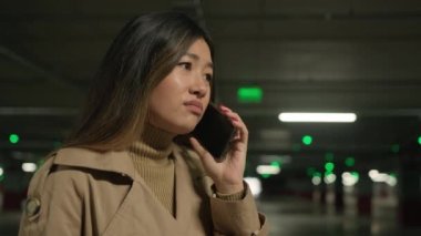 Endişeli Asyalı kadın üzgün, hayal kırıklığına uğramış, Koreli, Çinli, Japon kadın, cep telefonu, surat asma, umutsuzluk, kötü haber, park yerinde akıllı telefon, taksi, kötü servis.