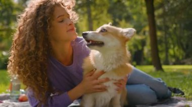 Beyaz mutlu kız çimenlerde altın yavru köpekle oynuyor yaz haftasonu kadın hayvan eğitmeni arkadaş evcil hayvan sever şehir parkında sevimli küçük köpek pembroke galsh corgi