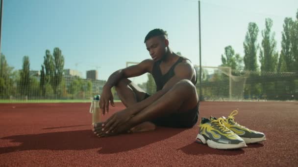Africký Američan Fotbalista Sedět Stadionu Pole Venku Tření Poškozené Nohy — Stock video