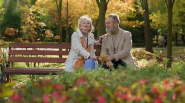 Yaşlı evli çift parkta sonbahar aşkı. Emeklilikte birlikte konuşuyorlar. Yetişkin bir adam yetişkin bir kadınla romantik bir randevu.