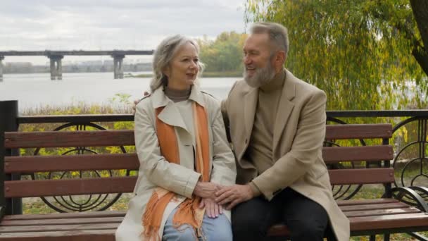 Glücklich Senior Mann Und Frau Reden Zusammen Auf Bank Freien — Stockvideo