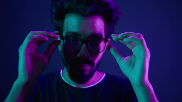 近景肖像画阿拉伯印度男人男程序员编码器戴眼镜3D尺寸焦距姿态洞察力好视力视力集中视力计算机在紫色霓虹灯背景下工作 — 图库视频影像