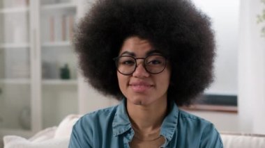 Afro-Amerikan mutlu, gözlüklü kız evinde kameraya gülümse kanepe kanepe etnik kadına evde tasasız resimli ev hanımı ev hanımı ev hanımı ev hanımı ev kredisi