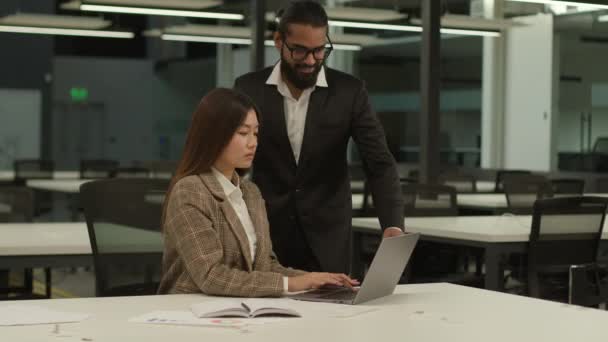 アジアのビジネスウーマンワーカー 韓国の女性マネージャー ノートパソコンのオンライン作業タスクをタイプする女性 アラビアのビジネスマン インドのビジネスリーダー メンターウォークチェック オフィスの2人のビジネス同僚を話すのに役立ちます — ストック動画