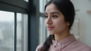 Düşünceli, hayalperest, genç Arap, Hintli, kız öğrenci pencereden dışarı bakıyor. Düşünceli, düşünceli, güzel bir bayan modelin evde tek başına yansımasını hayal ediyor.