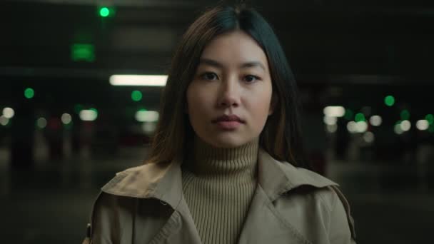 ポートレートを閉じる 落ち着いた深刻な自信を持つアジアの民族女性 平和な顔の感情 車の駐車場でカメラを見ている女性 韓国語 中国の女性 日本の女性 静かなビジネスウーマン ヘッドショット — ストック動画