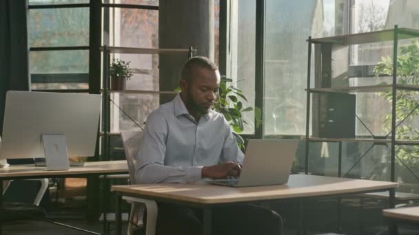 中年成人40代ビジネスマンアフリカ系アメリカ人エスニック労働者Ceoは コンピュータ検索データオンラインネットワーキングソフト笑顔に電子メールを入力する日当たりの良いオフィスビジネス代理店に座っています — ストック動画