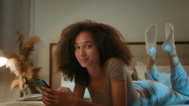 アフリカ系アメリカ人の遺伝子 エスニック 美しい 携帯電話 リラックス ベッド ホーム ユーザー ブラウジング スマートフォン — ストック動画