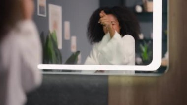 Afro-amerikan eğlenceli aktif kadın ayna yansımasına bakıyor banyoda dans ediyor eğleniyor güzel bir sabah keyfi yapıyor melez etnik kız bayan dans ediyor banyoda müzik eşliğinde
