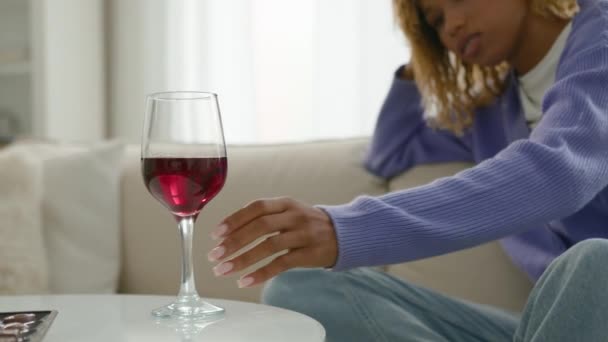 アフリカ系アメリカ人女性アルコール中毒女性一人でリラックスして考える問題はワイングラスを見て思慮深い赤ワインの飲み物のガラスを取る — ストック動画