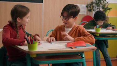Mutlu Kafkasyalı küçük okul çocukları kız çocukları öğrencileri okul çocukları sınıf arkadaşları birlikte görev alıştırması yapıyorlar kitap yazma çalışması öğreniyorlar yazı eğitimi için beşlik verin