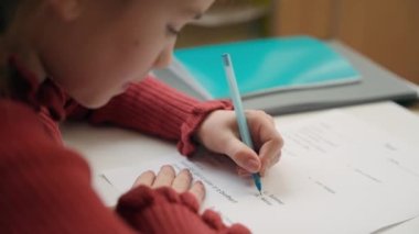 Kafkas zeki küçük kız dil sınavı yapıyor. Doğru cevabı seçiyor. Sınav notları yazıyor. Ders notları yazıyor.