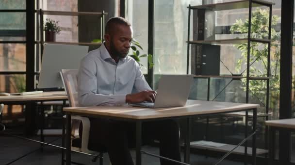 侧重于计算机工作的成年商人非裔美国人40多岁的男性工人雇主经理专业程序员在办公室工作场所的笔记本电脑上打字中年男性数据网络 — 图库视频影像