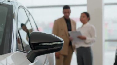 Modern araba satan kadının kanat aynasını kapat arka plan otomobil satıcısı ve müşteri kredisi satıcısı kredi anlaşmasında alıcıyla konuş galeride yeni otomobil satın alan aracı sat.