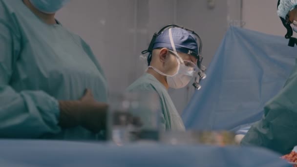 由专业外科医生组成的医生小组医生在手术室实施医疗手术 帮助护士站起来进行注射器吸脂神经外科手术 — 图库视频影像