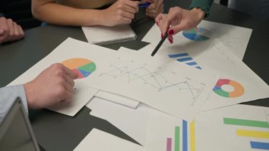 Masayı kağıtlarla kapayın. Kimliği belirsiz iş adamları grubu pazarlama araştırma sonuçlarını tartışıyor. Satış istatistiklerini gözden geçiriyor, veri analizi grafikleri planlanıyor.