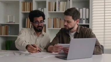İki çok ırklı iş arkadaşı ofiste mali veri projesi belgelerini tartışıyor. Kafkasyalı Hintli erkekler kütüphane sınıfı şirket çalışması tartışmasında sınav hazırlıyorlar.