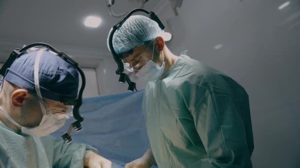 内科医生与实习医生一起实施外科手术男性切除阑尾炎肿瘤手术心脏肺胃切口缝合创面手术在临床医院的医疗保健 — 图库视频影像