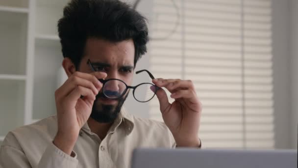 疲れた熟練した男 インドのアラビアのビジネスマン 眼鏡でラップトップに取り組んで 混乱したビジネス雇用主眼眼鏡の問題の視力チェック目視レーザー補正ヘルスケア — ストック動画