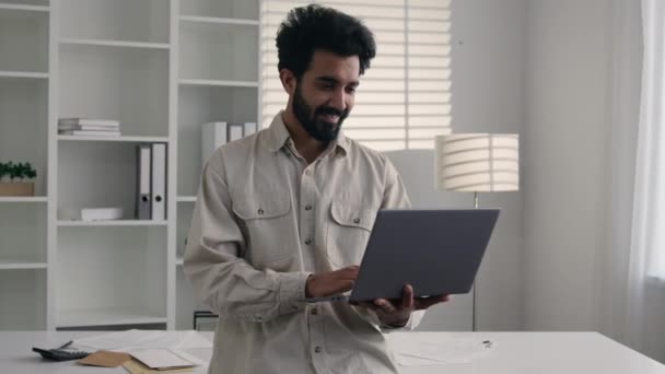 阿拉伯男子印度穆斯林商人雇员站在公司办公室与笔记本电脑微笑的企业家千禧年男性在线数字数据浏览电脑互联网 — 图库视频影像