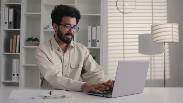 阿拉伯裔印度商人商人完成在线工作完成笔记本电脑上的项目庆祝成绩好的结果在办公室里 男性快乐商人欢欢喜喜地跳着成功的交易 — 图库视频影像