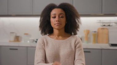 Afro-Amerikan etnik kız kendine güvenen kıvırcık saçlı kadın daire kiralıyor ev mutfağında kameraya bakıyor çapraz pozlar veriyor güzel kadın ev hanımı anne ev kadını portresi