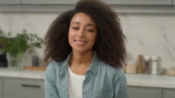 クローズアップ美しいアフリカ系アメリカ人微笑む幸せな女性 ハッピーなポジティブな女の子 自宅で一人立っている現代キッチン笑顔 カメラを見るかわいい髪の肖像画を持つ魅力的な民族女性 — ストック動画