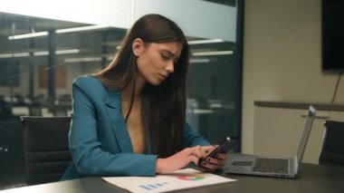 Arap kız Hintli iş kadını Kafkasyalı iş kadını masa başında renkli dizüstü bilgisayarı olan kötü haber akıllı telefon arızası mesajları okuyan tasarımcı cep telefonu kullanarak ofise bir kadın alıyor.