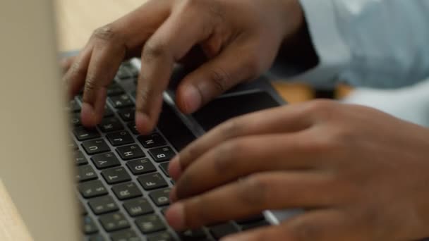 无法辨认的比尔卡商人学生在桌面上用计算机学习关闭了非洲裔美国男性用户的手在笔记本电脑键盘上打字商务人员在线学习技术 — 图库视频影像