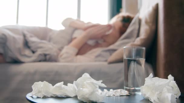 ウイルス風邪の頭痛の不健康な女性に苦しんでいる自宅のベッドで一人で病気の少女はティッシュナプキンで鼻を吹き飛ばすくしゃみのインフルエンザの症状を疲れました健康問題の伝染の狙いを捨てます — ストック動画