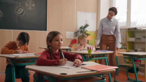 Lkokulda Sınıf Masaları Arasında Yürüyen Beyaz Kadın Öğretmen Öğretmenler Çocuklara — Stok video