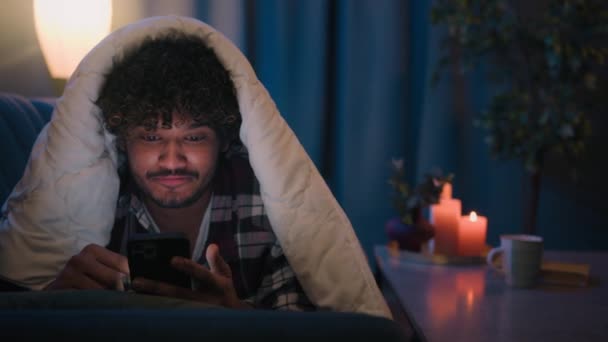 携帯電話中毒男性のユーザー インドの男は驚きました 驚いた 驚いた スマートフォンの読書ニュース 夜の毛布の下で アラビア人の男ショック サプライズ 電話の勝利 ワクワクする不眠症 — ストック動画