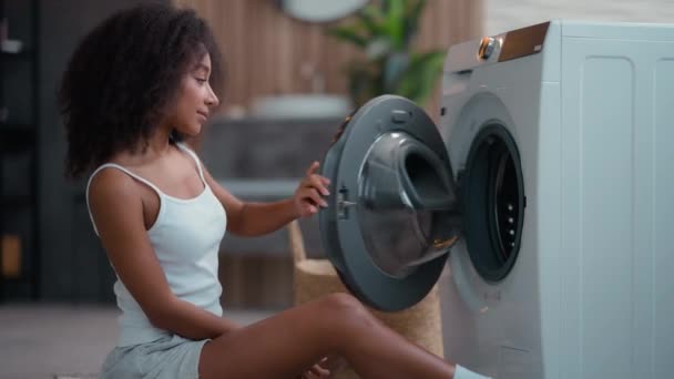 非洲裔美国妇女 单身女性家庭主妇 有洗衣店 有洗衣机 带着洁白干净的毛巾 闻起来好香 享受柔软的服装护发素拥抱拥抱 — 图库视频影像